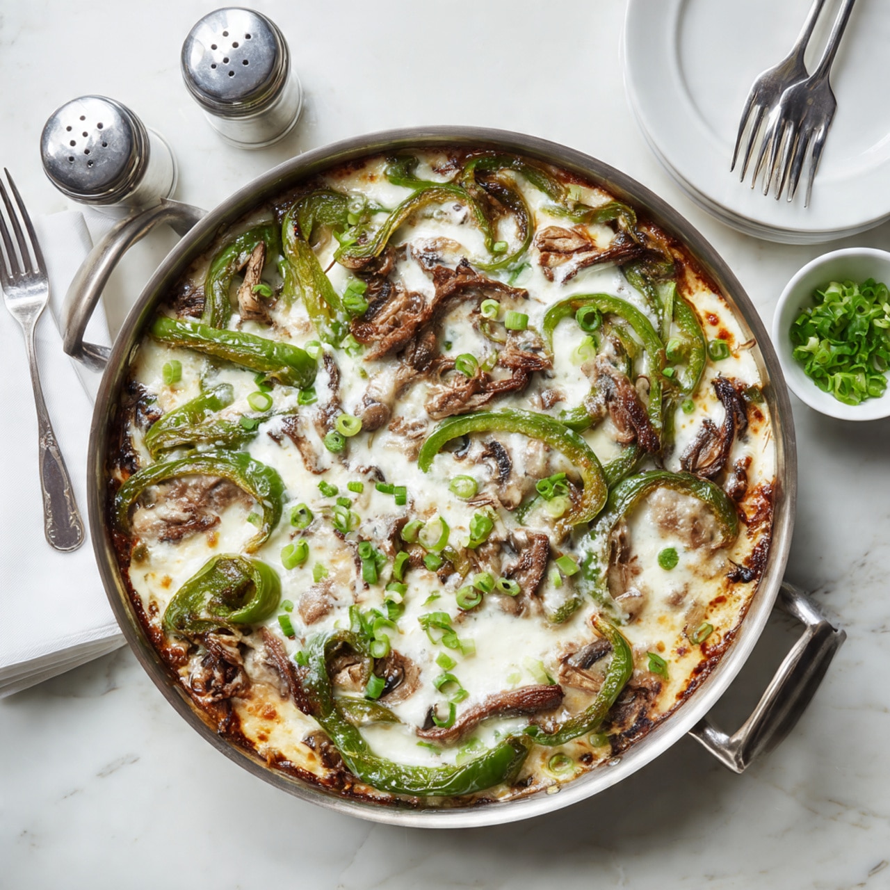 A close-up of a silver pan filled with a cheesy beef and vegetable dish. The bottom layer consists of sliced brown mushrooms, green bell pepper chunks, and caramelized onions. Above this is a layer of cooked thin beef strips. On top, there is a thick layer of melted, slightly browned white cheese stretching as a wooden spatula lifts some of the food. Scattered green onion pieces add a fresh pop of color. The background shows fresh green herbs on a white marbled surface. Photo taken with an iphone --ar 4:5 --v 7