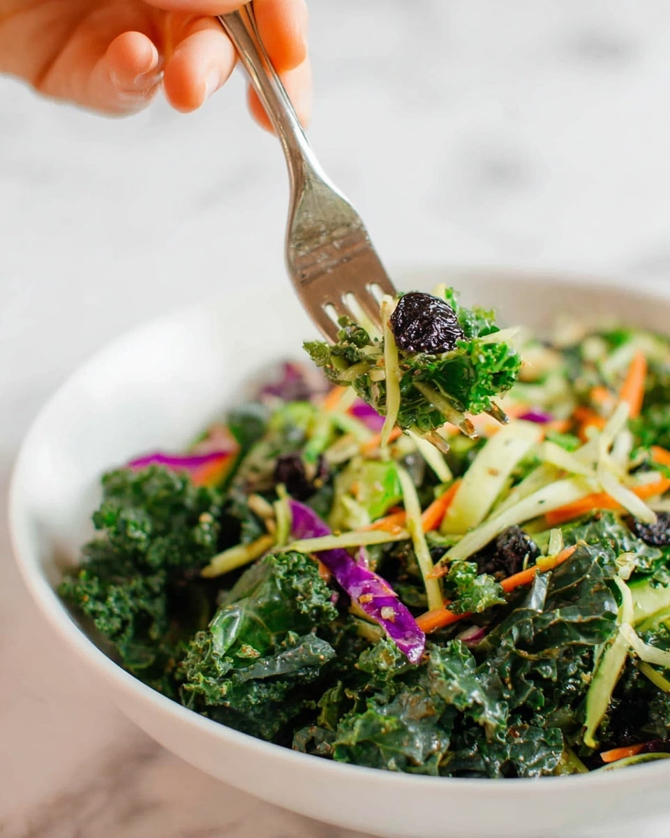 The image shows a close-up of a fresh salad in a white bowl placed on a white marbled surface. The salad has several layers of ingredients: a base of dark green curly kale leaves mixed with light green shredded cabbage and thin spinach strips, scattered with small pieces of orange carrot and bits of purple cabbage for color contrast. On top, there are a few small dark dried berries or olives adding dark spots. A woman's hand is holding a fork, lifting a portion of the salad that includes green leaves, shredded vegetables, and a piece of a light green vegetable, possibly celery, with a focus on the textures and fresh, vibrant colors of the salad ingredients. Photo taken with an iphone --ar 4:5 --v 7