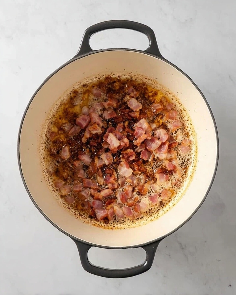 A round white pot with black handles is shown from above on a white marbled surface. Inside the pot, small pieces of cooked bacon are sizzling in oil, spread unevenly with some parts showing darker brown crispy bits and others with lighter pinkish cooked meat. The bottom of the pot has brown sear marks and bubbling oil around the bacon pieces, giving a textured look of cooking in progress. Photo taken with an iphone --ar 4:5 --v 7