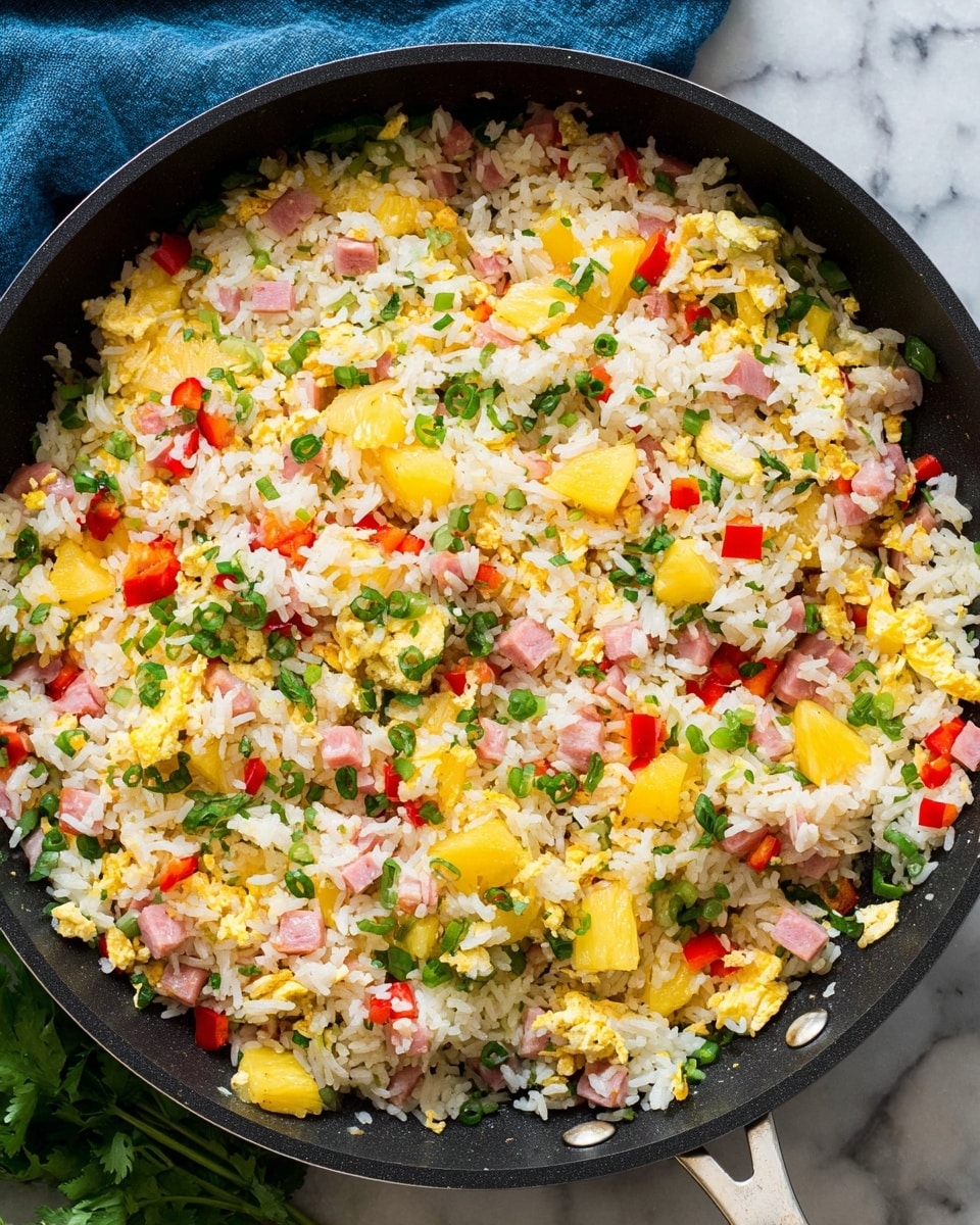 A large black frying pan filled with colorful fried rice, showing clear layers of white rice mixed with small yellow pineapple chunks, pink pieces of ham, bright red bell pepper cubes, and scattered green herbs including chopped spring onions and cilantro leaves. The food has a textured and slightly loose look with the ingredients evenly spread all over the pan. The background is a white marbled surface with a blue cloth partially visible near the top. Photo taken with an iphone --ar 4:5 --v 7