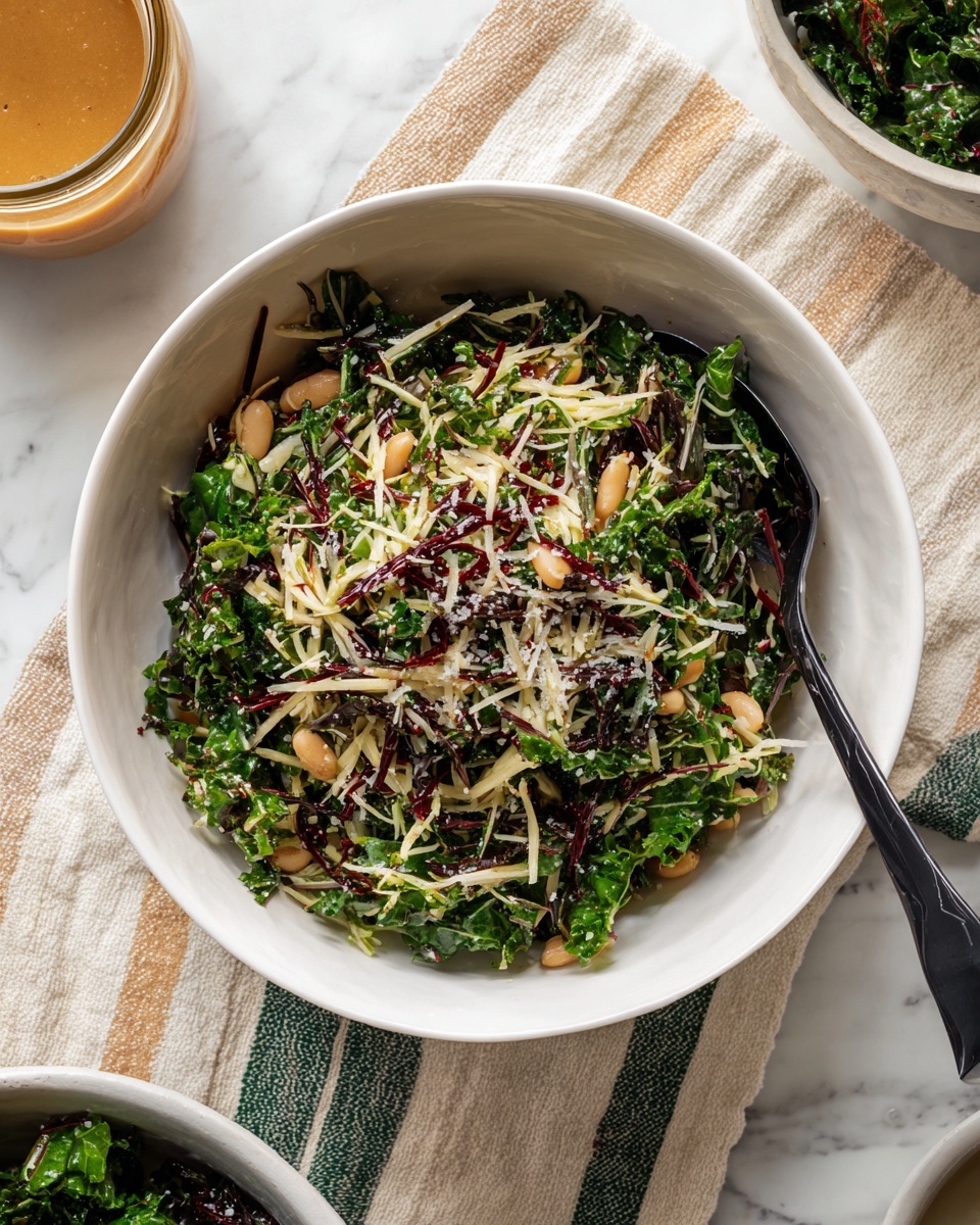 A white bowl filled with a salad made of shredded light green and dark green leafy vegetables mixed evenly with thin dark red strips, small round beige beans, and sprinkled with light grated cheese on top. A black spoon rests inside the bowl on the right side. The bowl sits on a cloth with beige and green stripes, which is laid on a white marbled surface with some small scattered pieces of leafy vegetables around. There are parts of another white bowl and a glass jar with a light brown sauce visible at the top edge of the image. Photo taken with an iphone --ar 4:5 --v 7