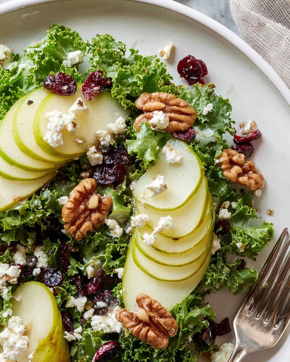 The dish is a salad served on a white plate with a white marbled texture surface beneath. The base layer is fresh curly green kale leaves spread across the plate, creating a vibrant green bed. On top, there are two groups of thinly sliced green pears arranged in neat, overlapping slivers on the right and bottom left sides of the kale. Scattered around are small clusters of roasted brown walnuts and dark red dried cranberries. White crumbles of soft cheese are sprinkled evenly over the salad, adding contrast and texture. A fork is partially visible near the bottom right edge of the plate, and the overall lighting is bright and natural. Photo taken with an iphone --ar 4:5 --v 7
