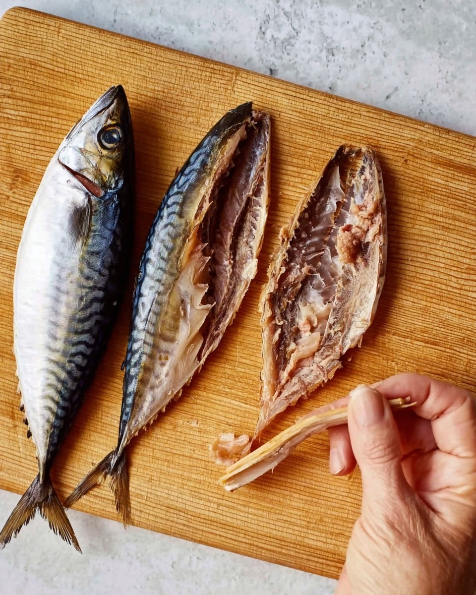 The image shows a wooden cutting board on a white marbled surface with two shiny silver mackerel fish sliced open and laid flat. One fish is intact and positioned on the left side of the board, displaying a smooth, silvery skin with dark spots. The other fish is fully opened showing its inside flesh, which is light pinkish-brown and flaky with some bones visible. A woman's hand is gently pulling a thin, curved bone from the opened fish. The wooden board has a natural, smooth texture with visible grain lines. photo taken with an iphone --ar 4:5 --v 7