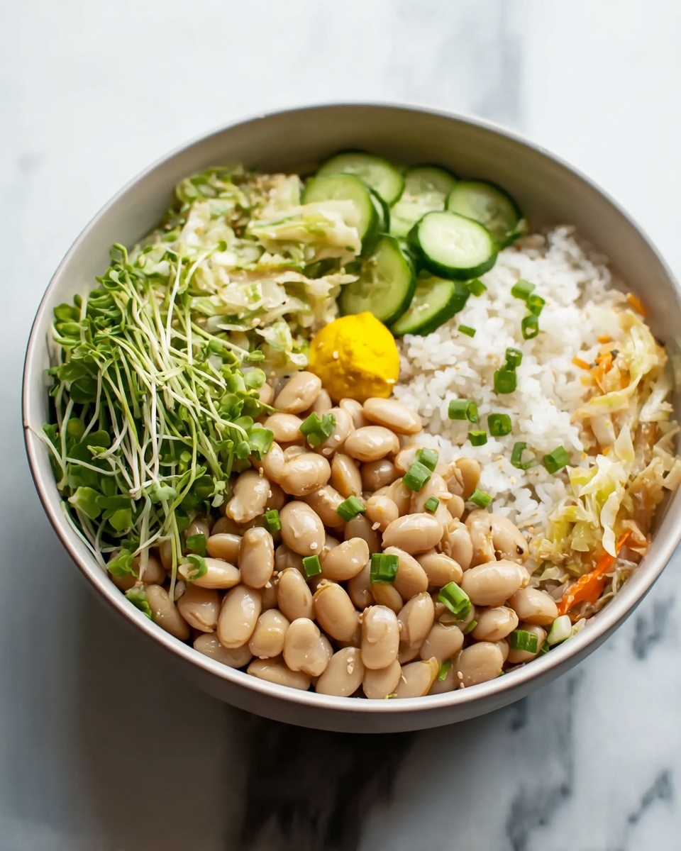 A white bowl filled with four layers of food placed on a white marbled surface; the bottom layer is white rice, topped with beige soft beans sprinkled with small green chive pieces, to one side there is a small round section of bright yellow mustard, the other side holds thinly sliced green cucumbers, and next to that is a mix of shredded white and orange vegetables, likely cabbage and carrot, all visible under the beans and fresh green leafy sprouts. Photo taken with an iphone --ar 4:5 --v 7