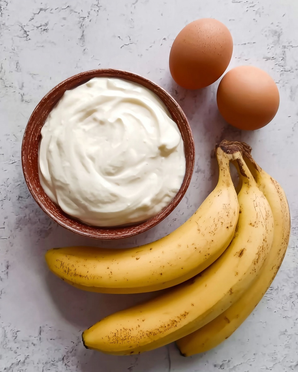 The image shows a brown bowl filled with smooth, white yogurt placed on a white marbled surface. Next to the bowl, two whole brown eggs rest side by side near the top right. In front of the bowl and eggs, two yellow bananas with small brown spots lay diagonally, one slightly overlapping the other. The surface has a subtle white marble pattern, and everything is lit softly, giving a clean and fresh look photo taken with an iphone --ar 4:5 --v 7