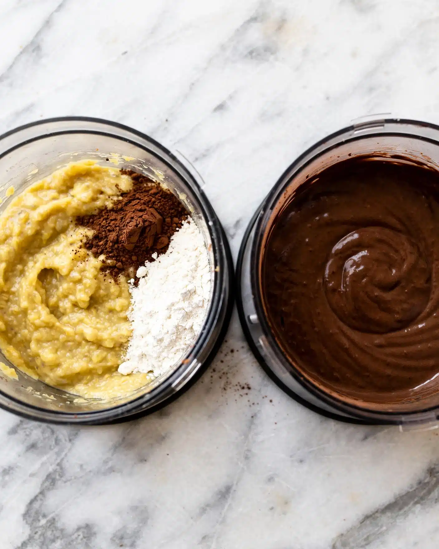 Image shows two top-down views of a food processor bowl on a white marbled surface. The left bowl contains a yellowish thick paste with a pile of white powder and dark brown cocoa powder sitting on top on the right side. The right bowl shows the same mixture blended into a smooth, dark brown batter covering the whole inside of the transparent food processor bowl. Photo taken with an iphone --ar 4:5 --v 7